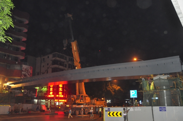 长38米、沉达87吨的钢箱梁，被200吨吊车稳稳地吊装在两个桥梁墩柱之上