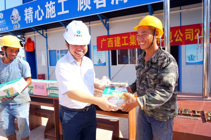 岑廷义为工人发放清冷慰问品。谢微旋 摄.jpg